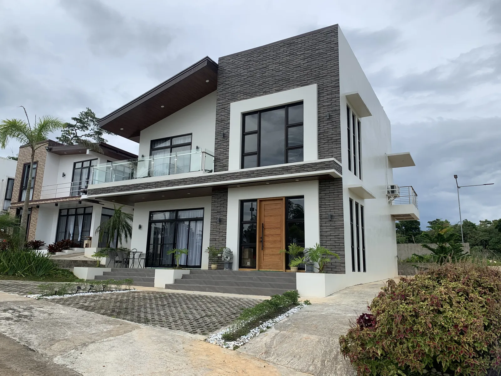 Two-storey house with stone cladding and large glass doors