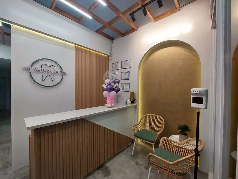 Dental clinic reception with a timber counter, an arched alcove and rattan chairs